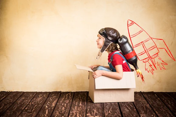 A boy sitting in a box pretending to be in a rocket