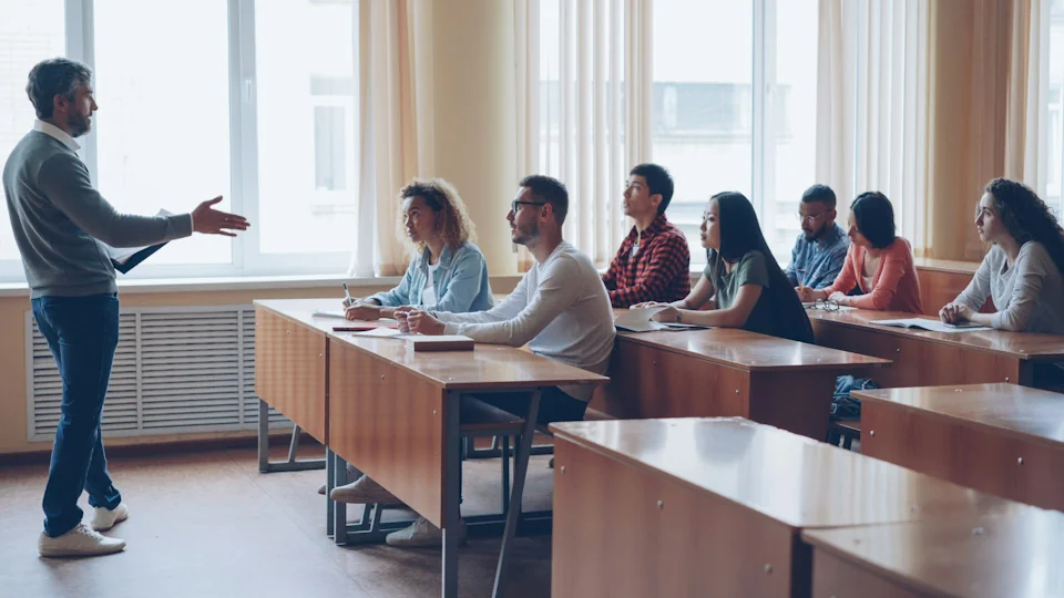 A teacher in front of a classroom of adults